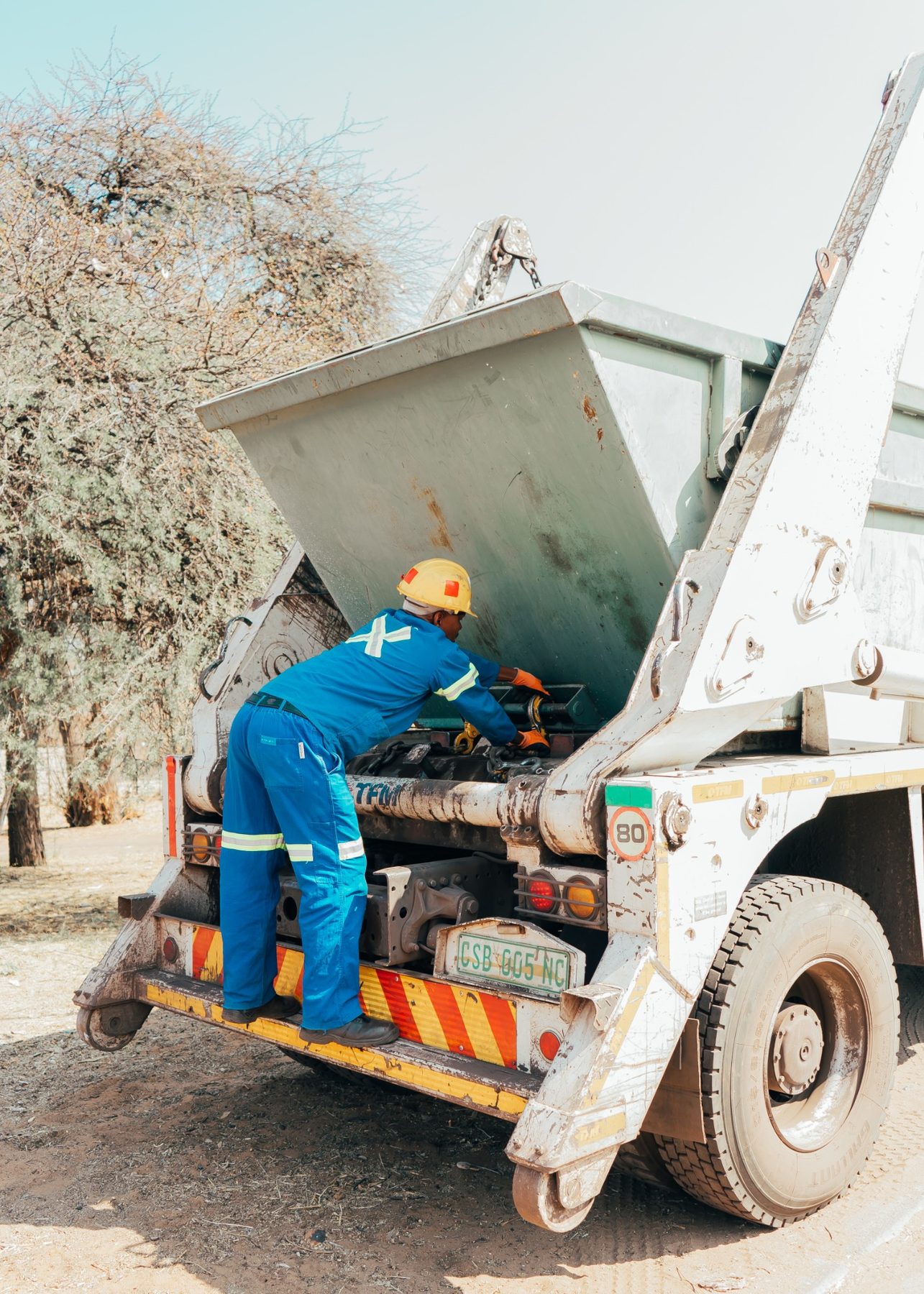 African Eagle employee loading a waste skip onto a collection vehicle